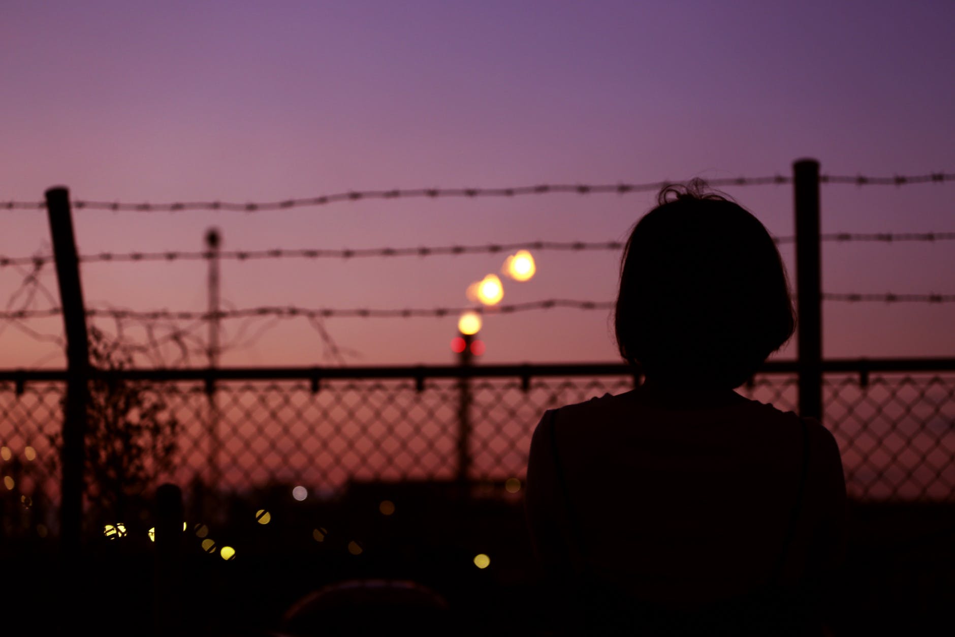 silhouette of person in front of fence