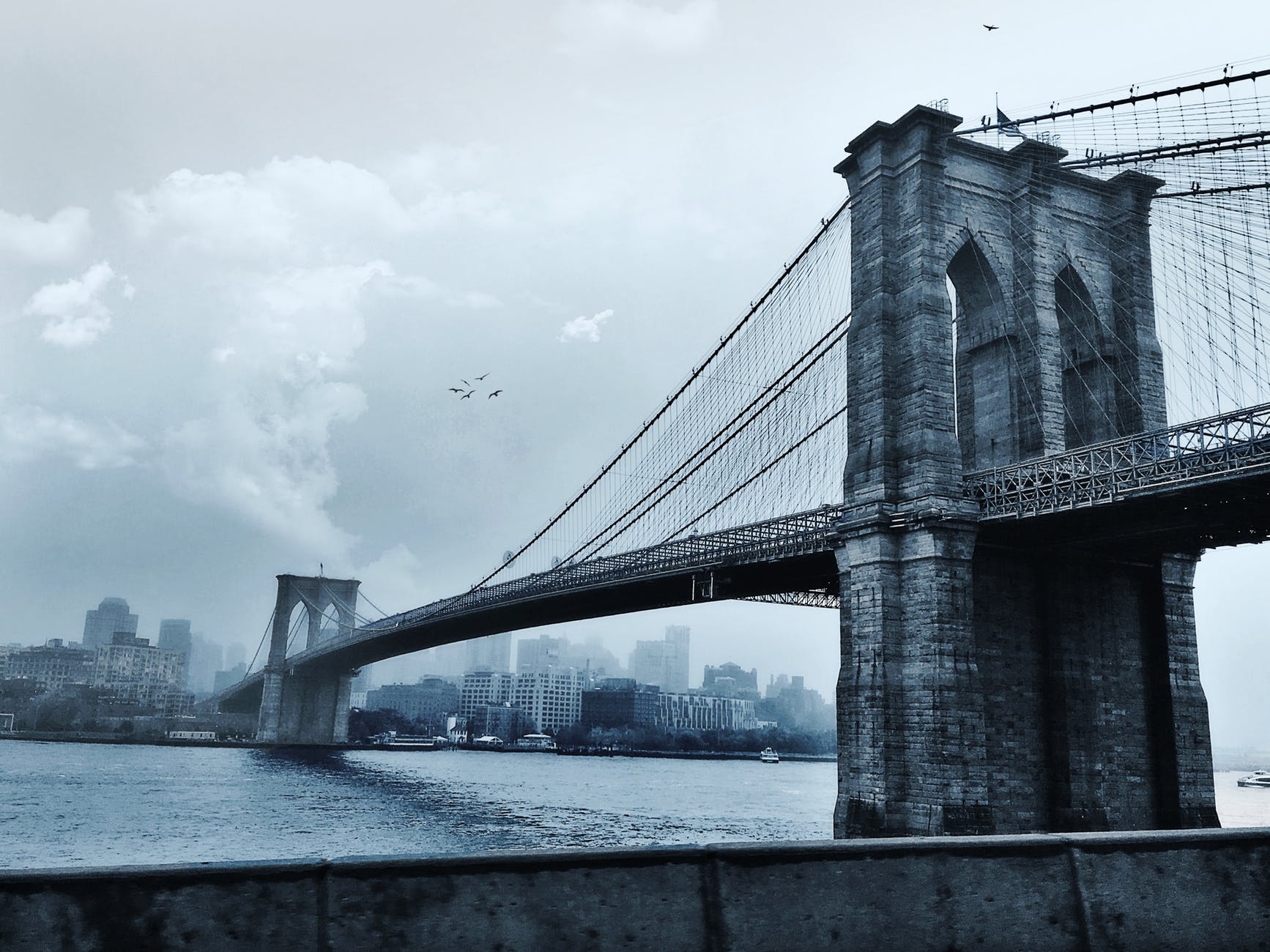 photo of suspension bridge under cloudy sky