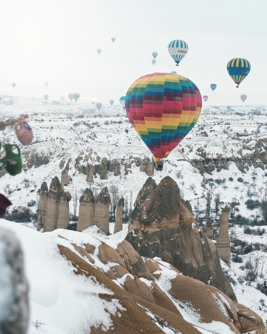 hot air balloons over snow covered mountain